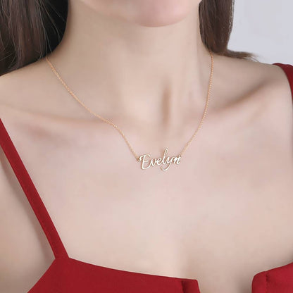 Model wearing a rose-gold-tone script name necklace with a red top