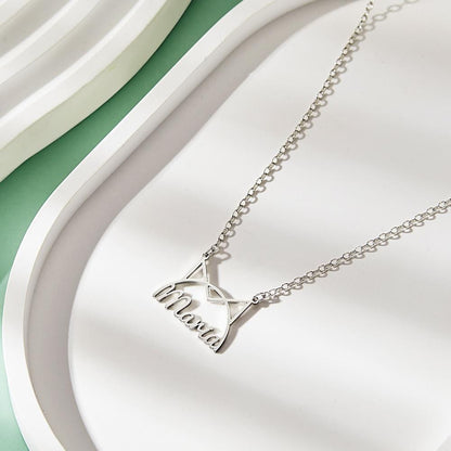 Silver-tone cat-ear name necklace displayed on a white tray